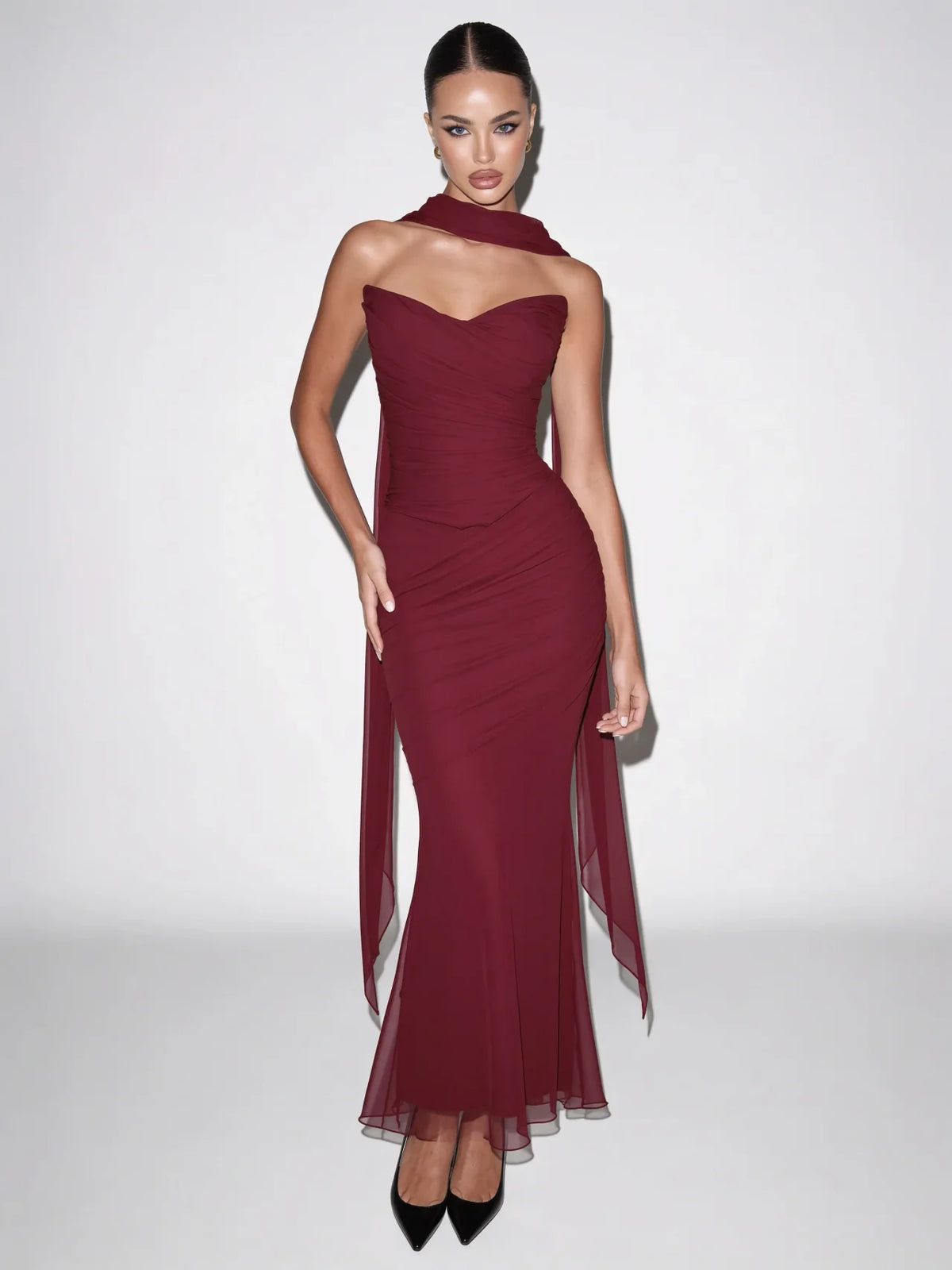 Burgundy red strapless maxi dress with sculpted ruched bodice and fitted skirt